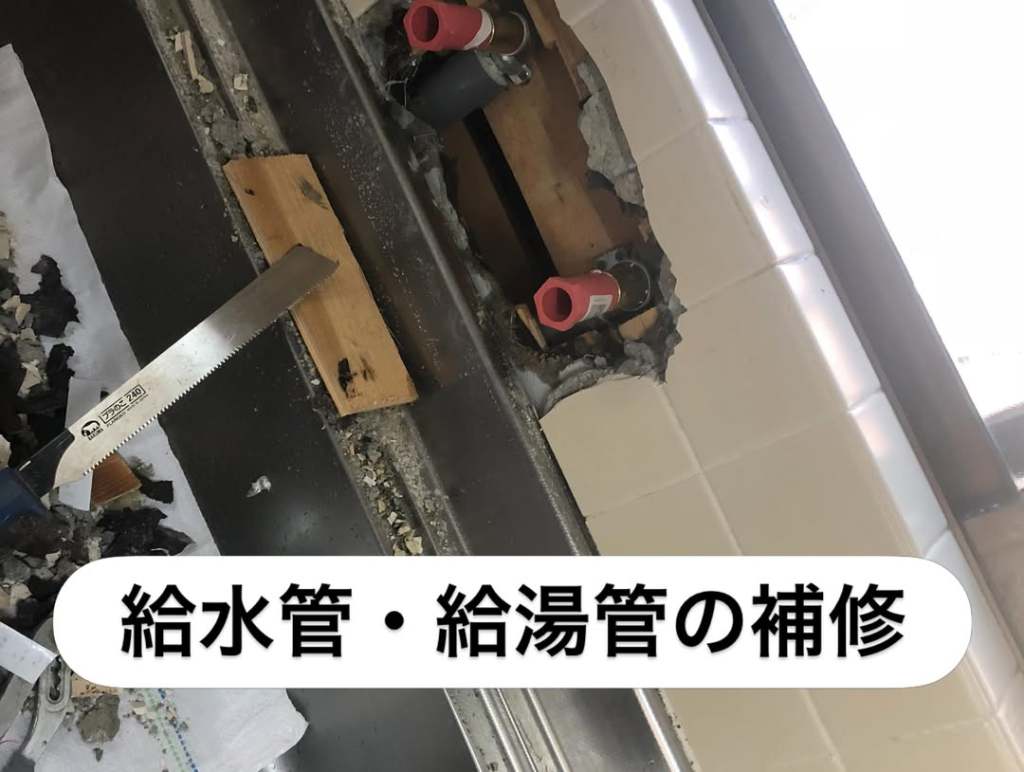 給水管と給湯管の補修作業中の写真。壁に開けた穴から配管が見え、周囲には切り取られた素材や工具が置かれている。