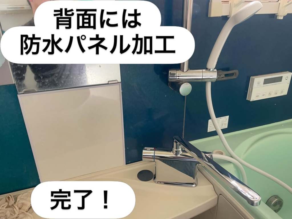 防水パネルが設置された浴室の一部を示す画像。蛇口とシャワーがあります。